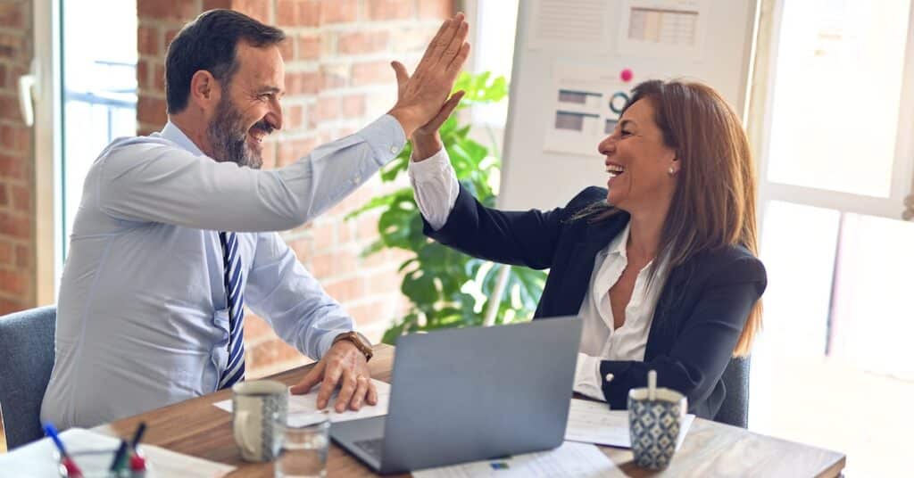 Happy employees high five each other