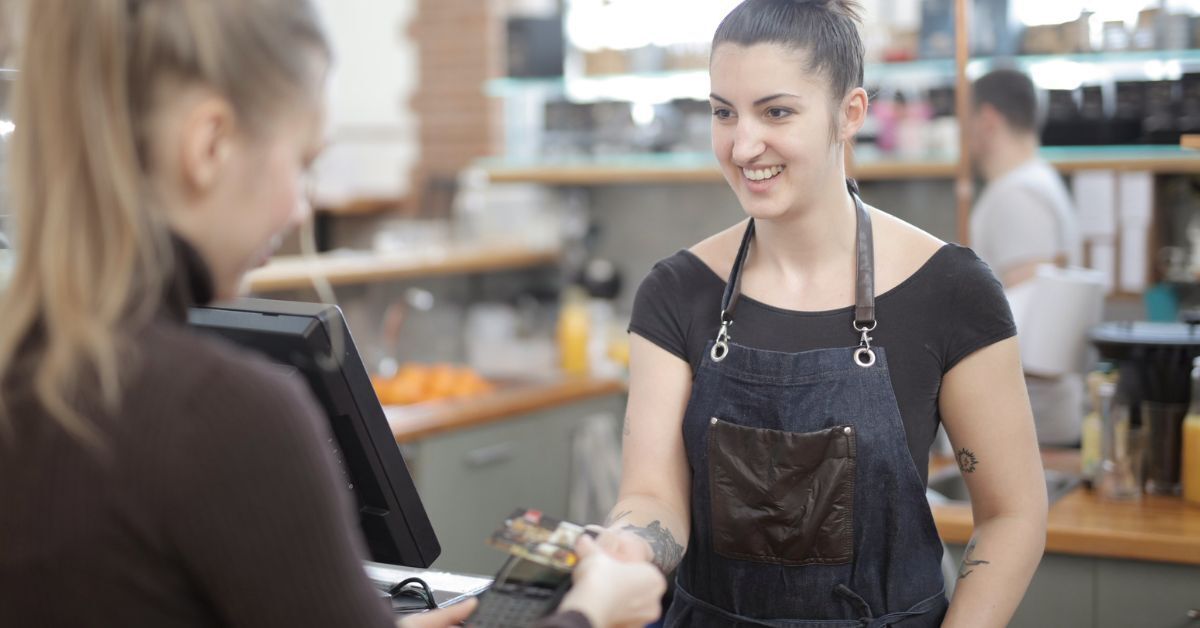 Cashier helps a client behind POS for gas stations
